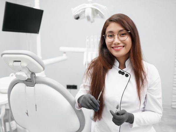 dentista-manteniendo-herramientas-dentales-y-sonriendo-en-la-clinica dentista-manteniendo-herramientas-dentales-y-sonriendo-en-la-clinica